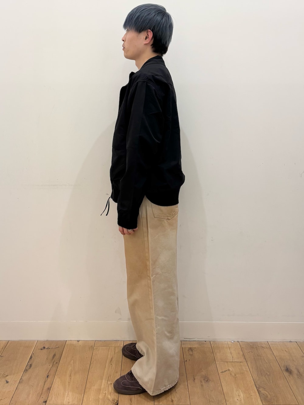 ブラック系のブルゾン、レッド系のスウェット、グリーン系のデニムパンツを着用したメンズの春コーディネートの3枚目の写真