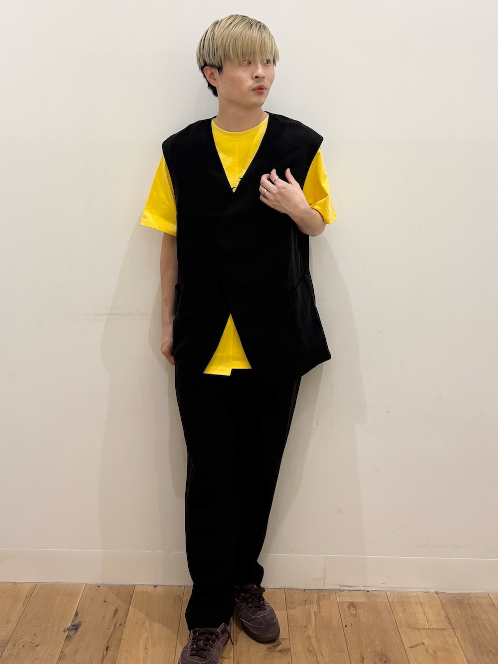 イエロー系のTシャツ/カットソー、ブラック系のダウンベスト、ブラック系のその他パンツを着用したメンズの夏コーディネートの2枚目の写真