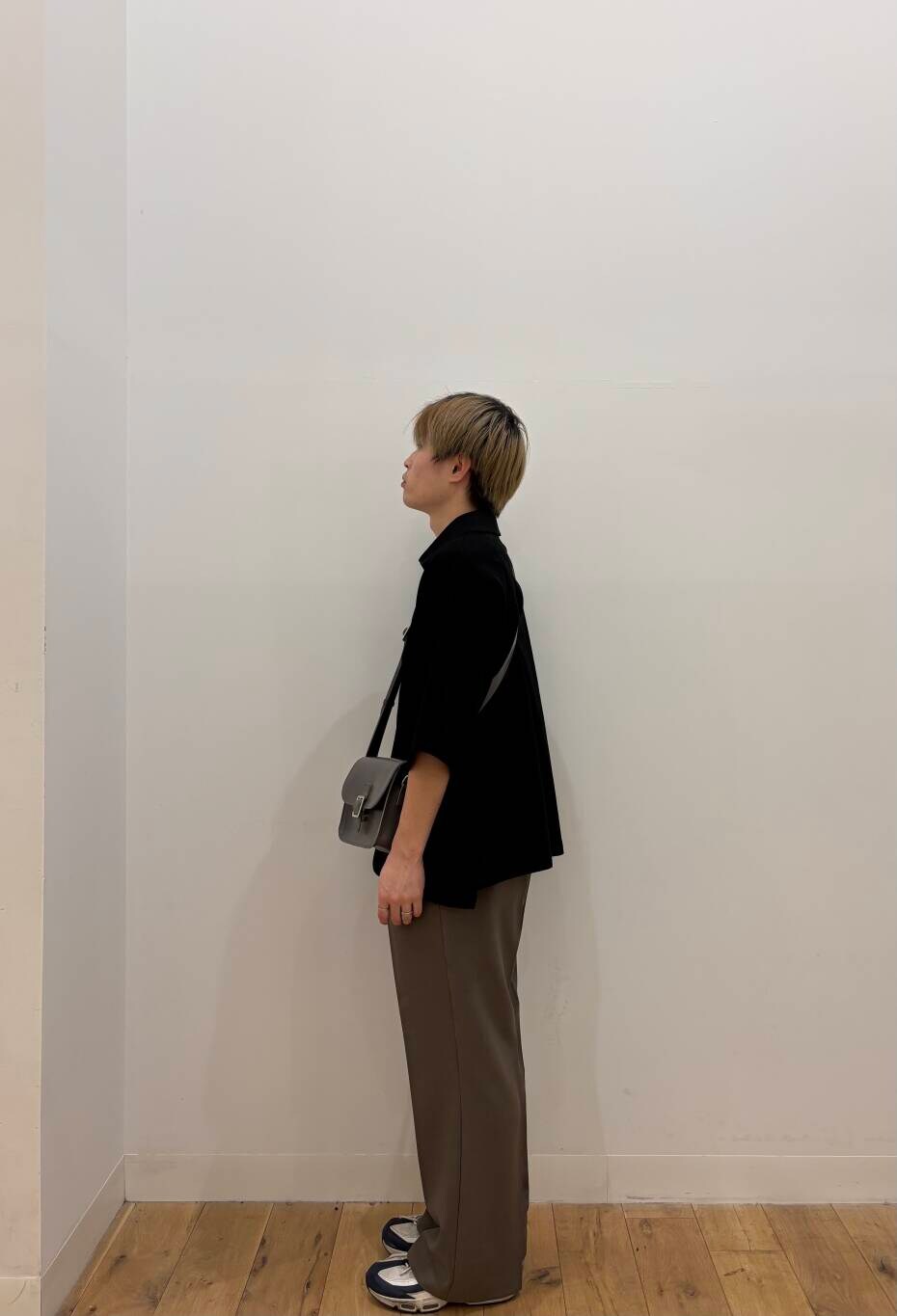 グレー系のショルダーバッグ、ブラウン系のその他パンツ、ブラック系のTシャツ/カットソーを着用したメンズの春コーディネートの3枚目の写真