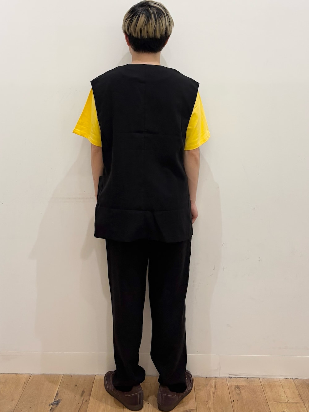 イエロー系のTシャツ/カットソー、ブラック系のダウンベスト、ブラック系のその他パンツを着用したメンズの夏コーディネートの4枚目の写真