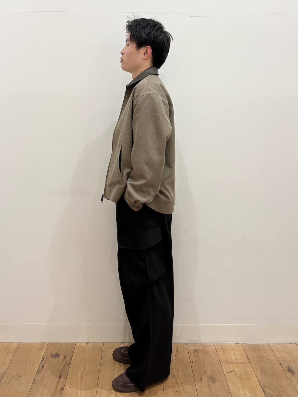 ブラウン系のブルゾン、グレー系のTシャツ/カットソー、ブラック系のカーゴパンツを着用したメンズの冬コーディネートの2枚目の写真