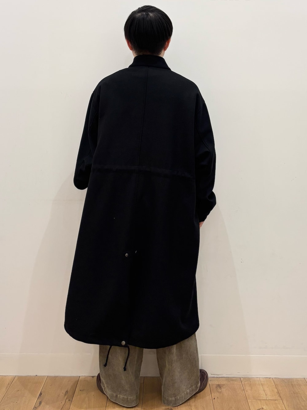 ブラック系のモッズコート、ベージュ系のその他パンツ、ブラウン系のニット/セーターを着用したメンズの冬コーディネートの5枚目の写真