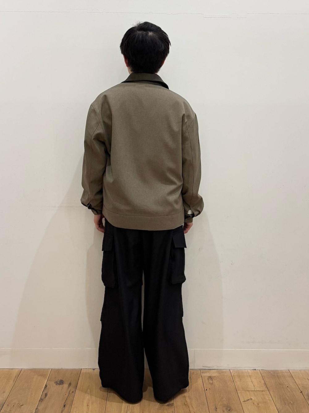 ブラウン系のブルゾン、グレー系のTシャツ/カットソー、ブラック系のカーゴパンツを着用したメンズの冬コーディネートの3枚目の写真