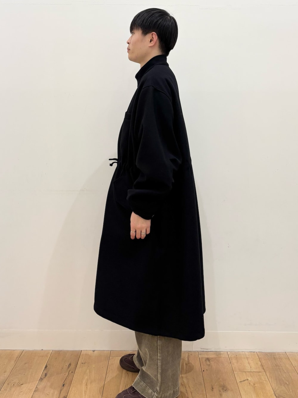 ブラック系のモッズコート、ベージュ系のその他パンツ、ブラウン系のニット/セーターを着用したメンズの冬コーディネートの4枚目の写真