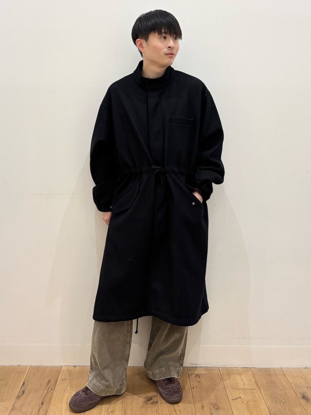 ブラック系のモッズコート、ベージュ系のその他パンツ、ブラウン系のニット/セーターを着用したメンズの冬コーディネートの2枚目の写真