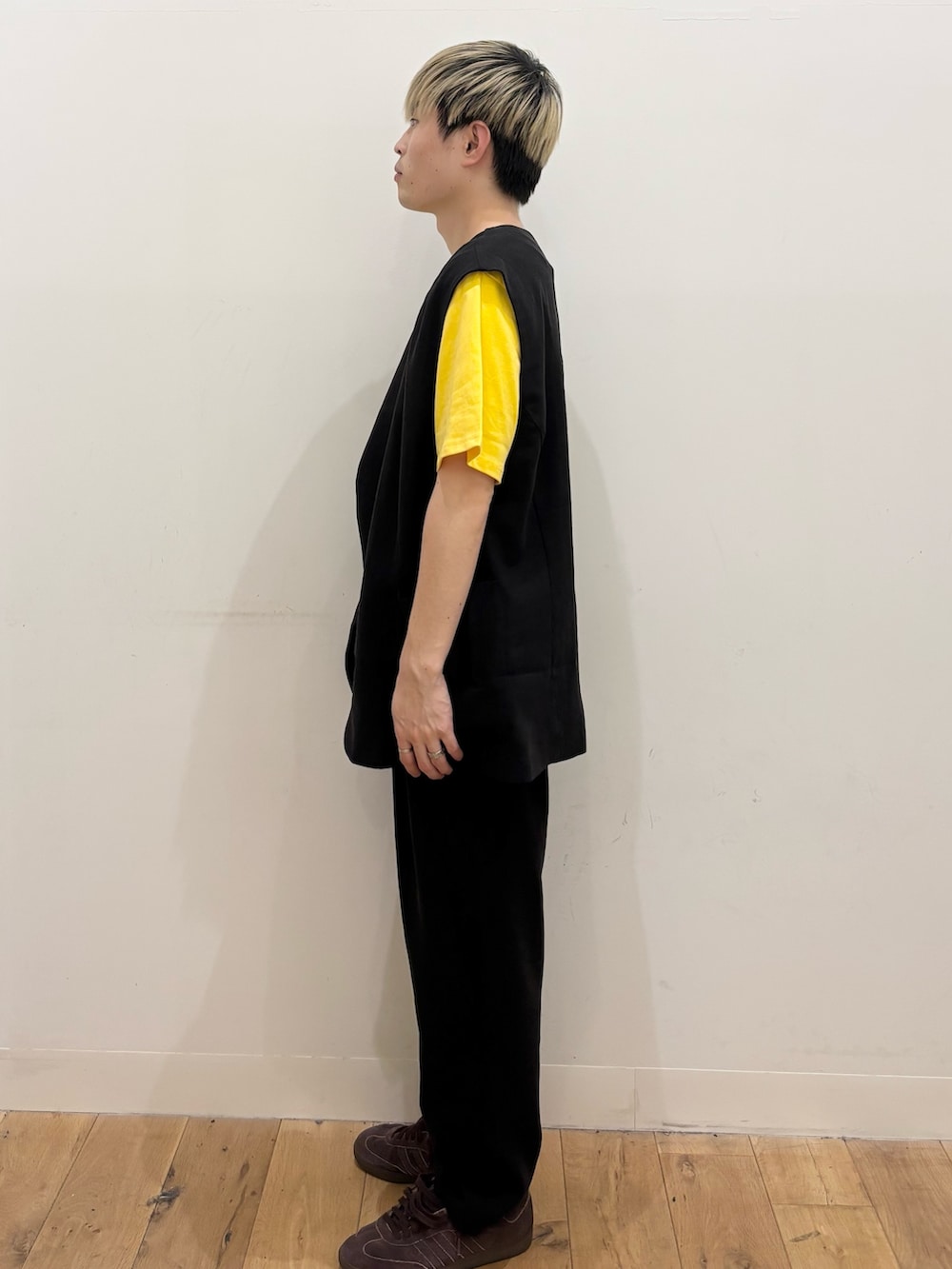 イエロー系のTシャツ/カットソー、ブラック系のダウンベスト、ブラック系のその他パンツを着用したメンズの夏コーディネートの3枚目の写真