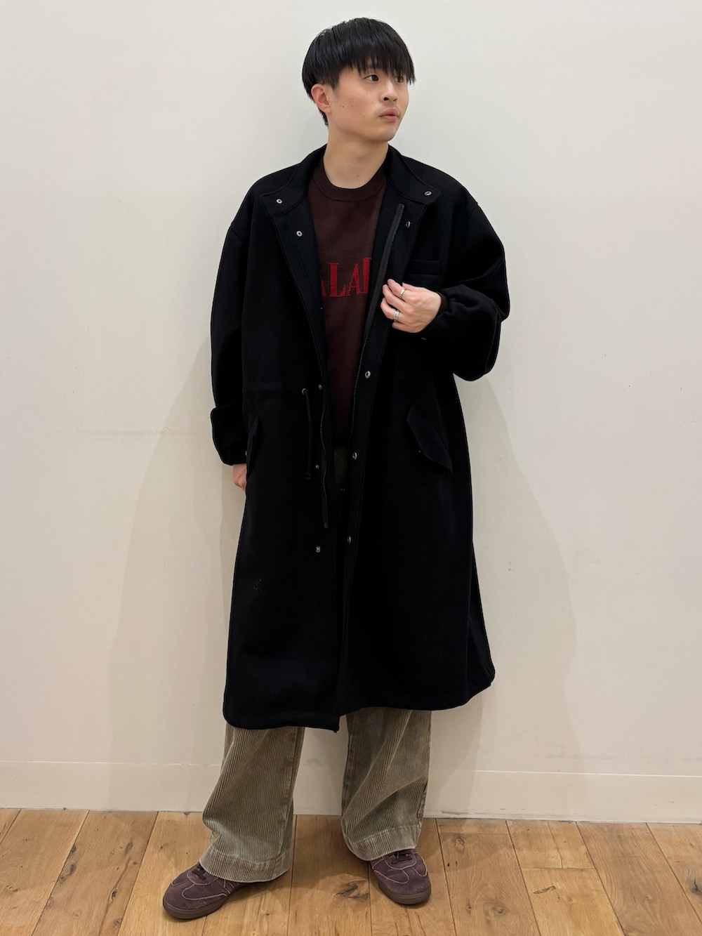 ブラック系のモッズコート、ベージュ系のその他パンツ、ブラウン系のニット/セーターを着用したメンズの冬コーディネートの3枚目の写真