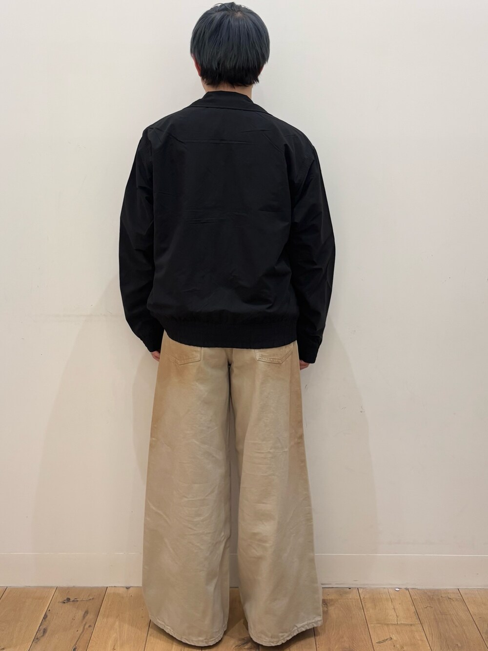 ブラック系のブルゾン、レッド系のスウェット、グリーン系のデニムパンツを着用したメンズの春コーディネートの4枚目の写真