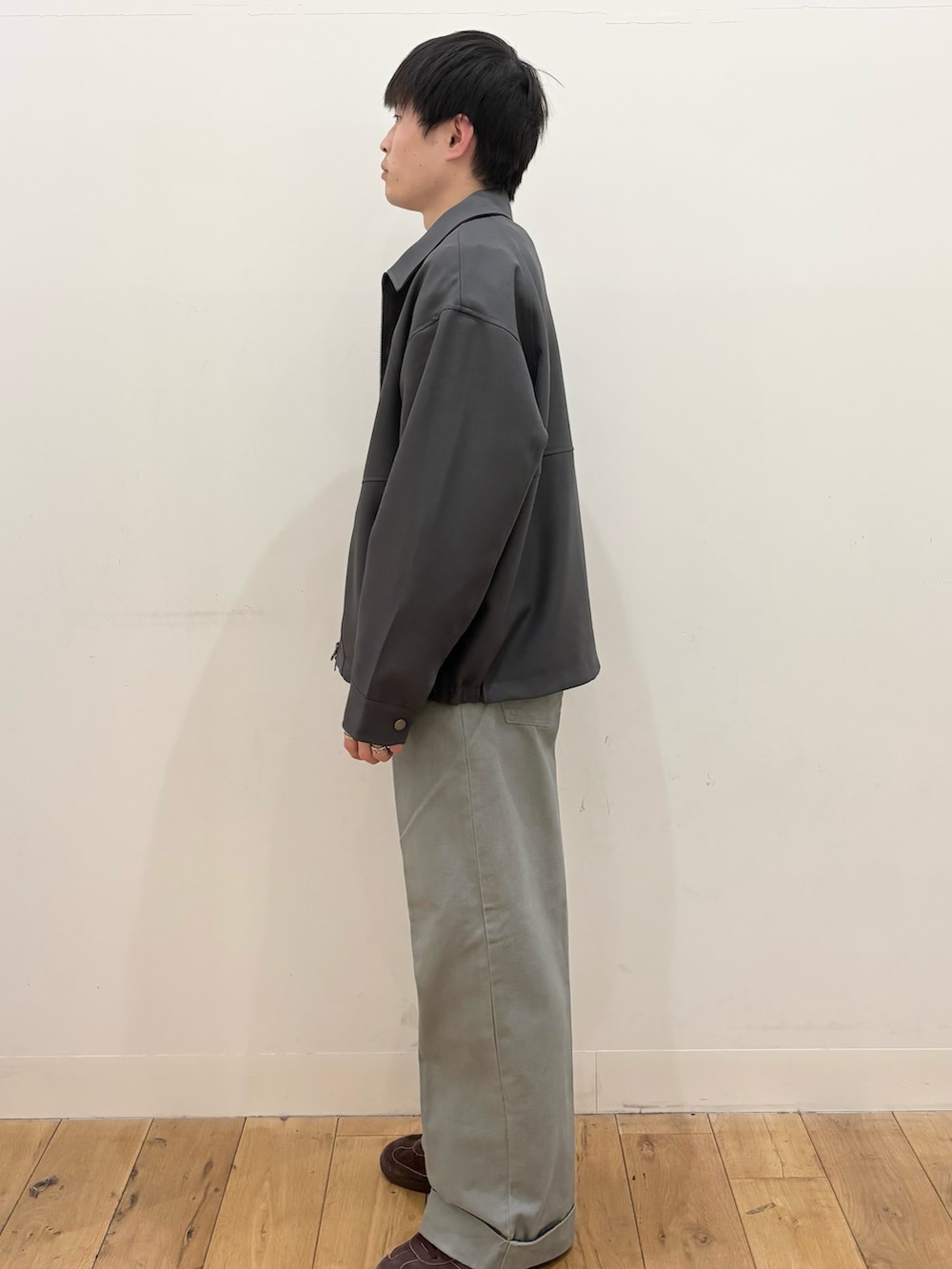 ブラック系のニット/セーター、ブルー系のブルゾン、ブルー系のその他パンツを着用したメンズの春コーディネートの2枚目の写真