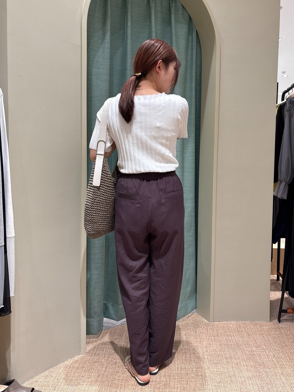 グレー系のその他パンツ、ホワイト系のニット/セーター、ホワイト系のトートバッグを着用したレディースの春コーディネートの2枚目の写真