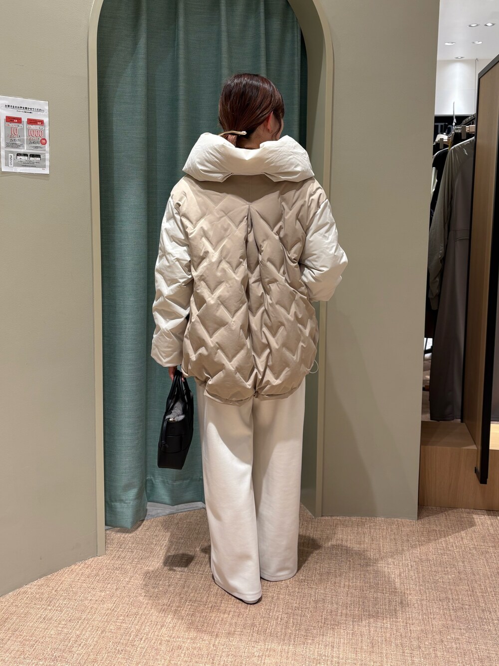 ホワイト系のその他パンツ、ブラック系のトートバッグ、ホワイト系のダウンジャケット/コートを着用したレディースの秋コーディネートの2枚目の写真