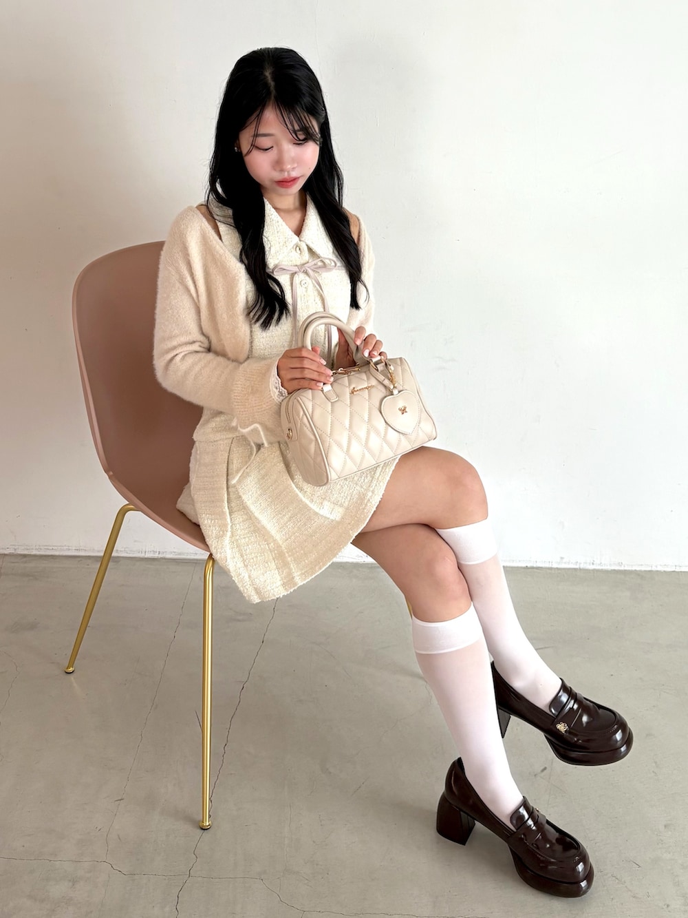 ホワイト系のワンピース、ブラウン系のローファー、ホワイト系のボストンバッグを着用したレディースの夏コーディネートの2枚目の写真