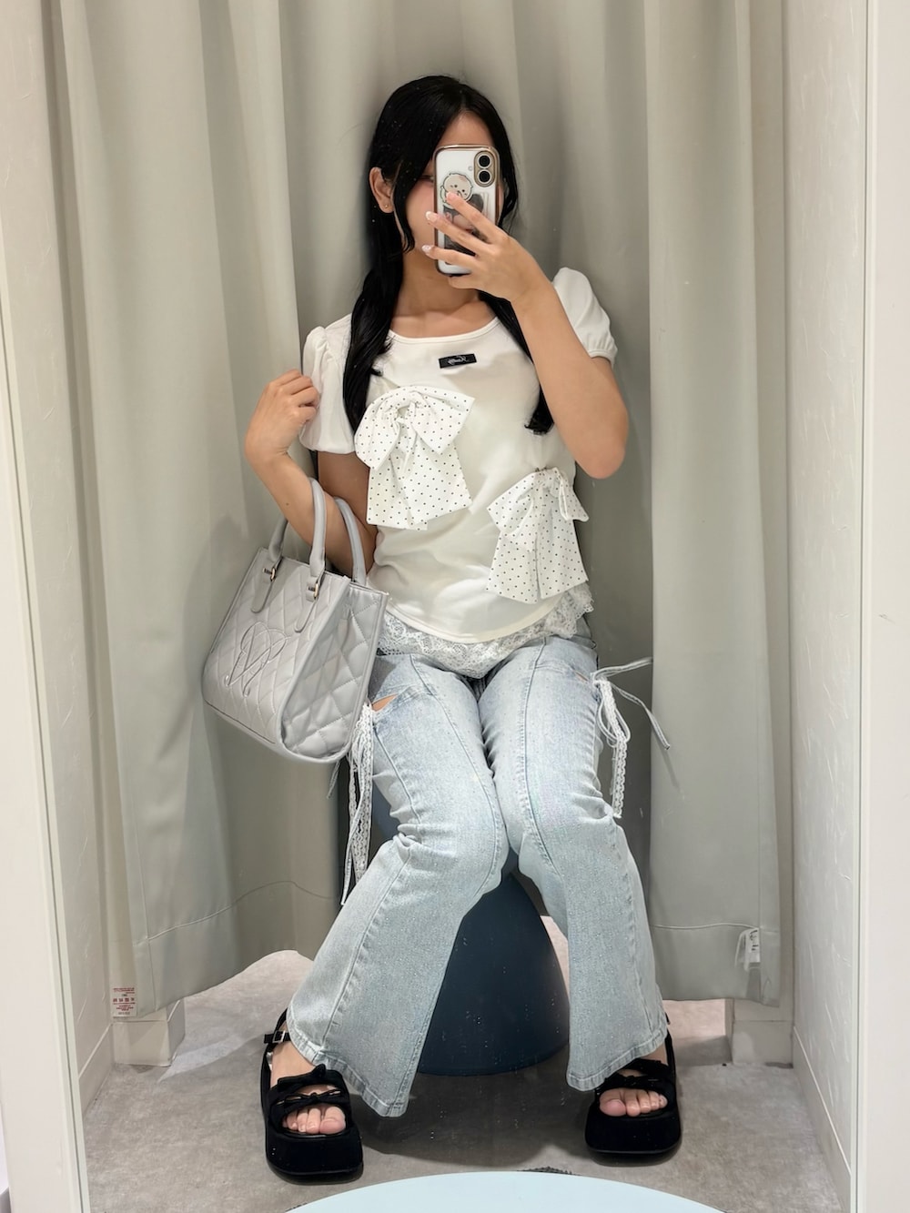 ホワイト系のTシャツ/カットソー、ブルー系のデニムパンツ、グレー系のショルダーバッグを着用したレディースの春コーディネートの2枚目の写真