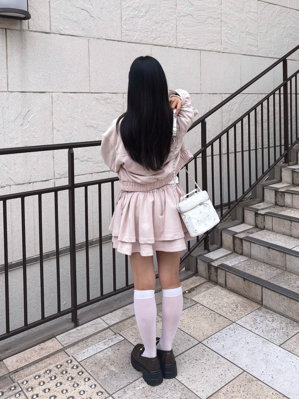 ピンク系のブルゾン、ピンク系のスカート、ホワイト系のニット/セーターを着用したレディースの冬コーディネートの2枚目の写真