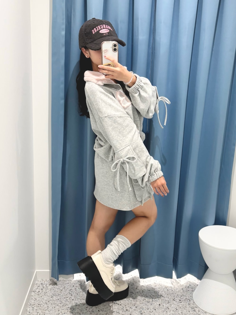 グレー系のTシャツ/カットソー、グレー系のスカート、ホワイト系のその他シューズを着用したレディースの秋コーディネートの2枚目の写真