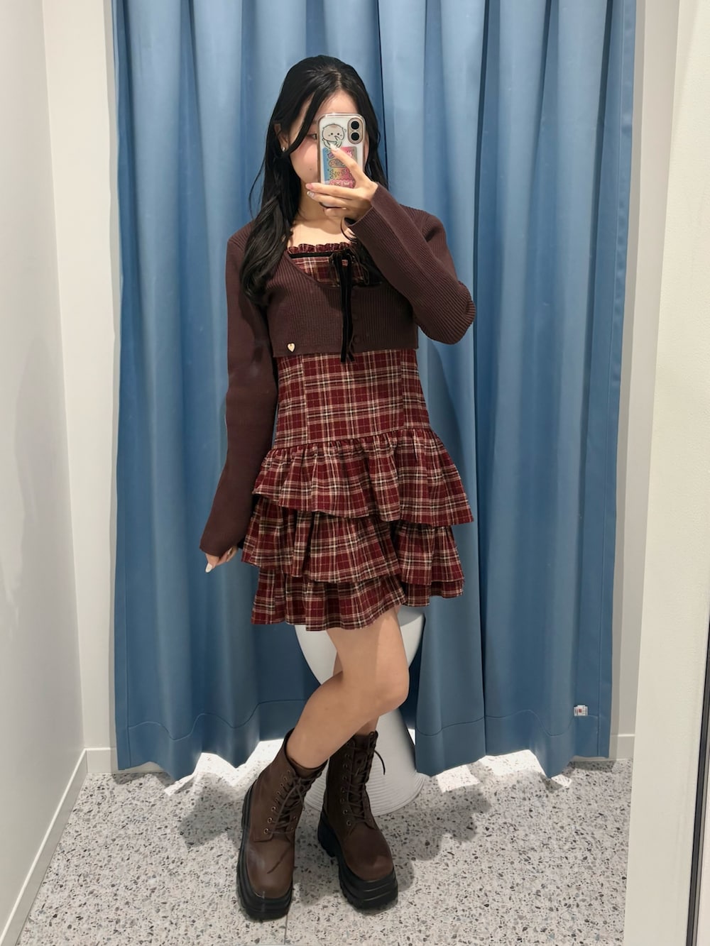 レッド系のワンピース、ブラウン系のブーツを着用したレディースの冬コーディネートの2枚目の写真