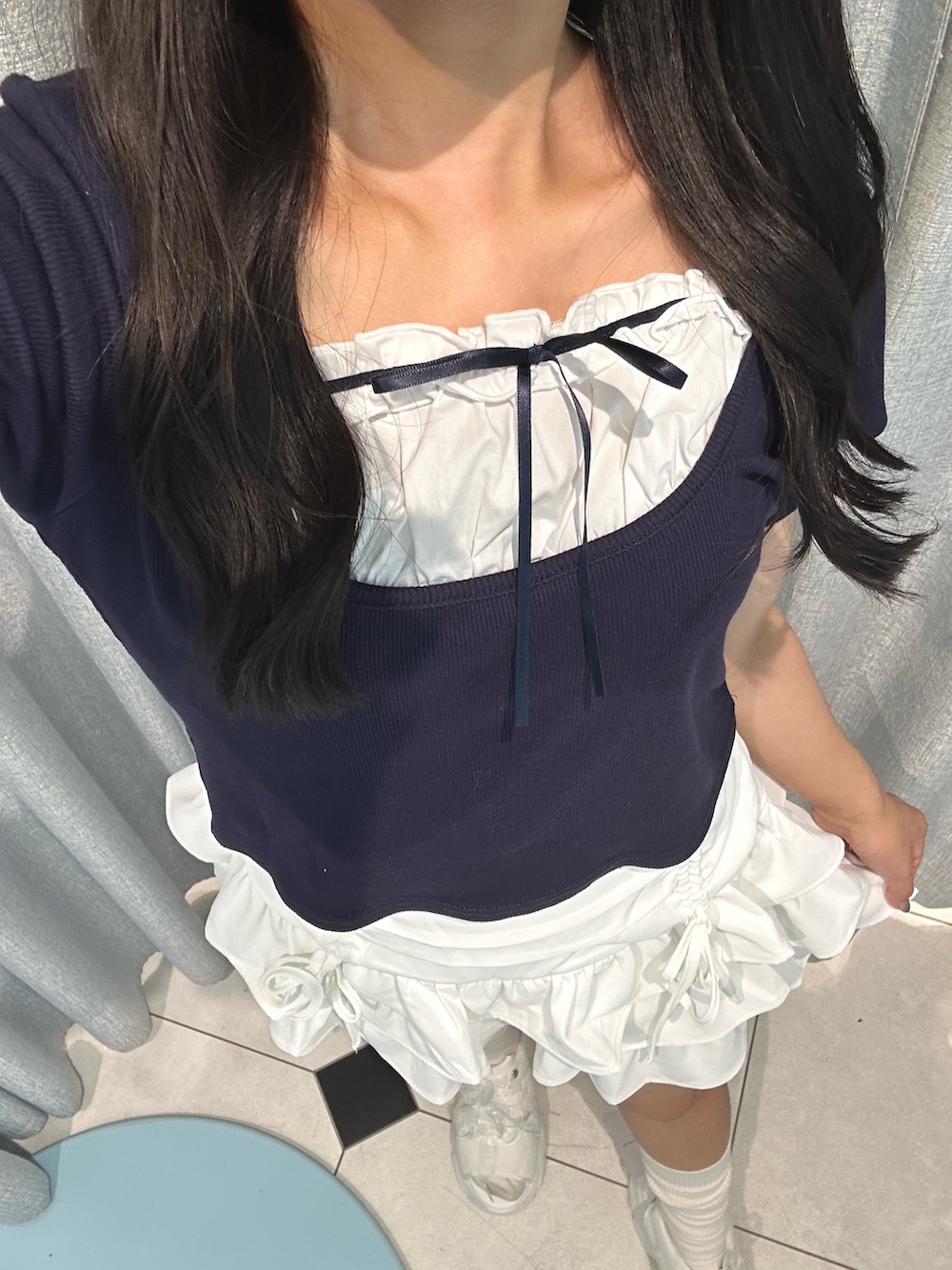 ホワイト系のスカート、ブルー系のTシャツ/カットソー、ホワイト系のサンダルを着用したレディースの夏コーディネートの3枚目の写真