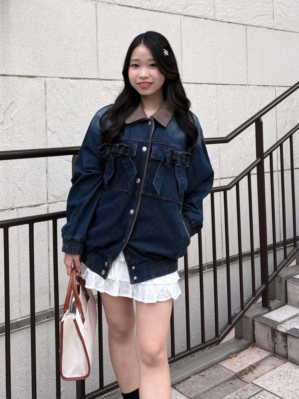 ブルー系のブルゾン、ブラウン系のトートバッグ、ホワイト系のスカートを着用したレディースの冬コーディネートの5枚目の写真