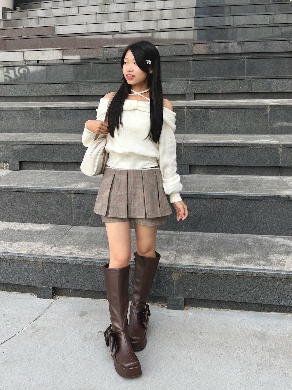 ホワイト系のニット/セーター、ブラウン系のその他パンツ、ブラウン系のブーツを着用したレディースの秋コーディネートの2枚目の写真