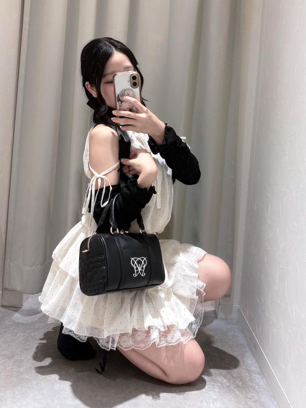 ホワイト系のワンピース、ブラック系のボストンバッグ、ブラック系のサンダルを着用したレディースの夏コーディネートの3枚目の写真
