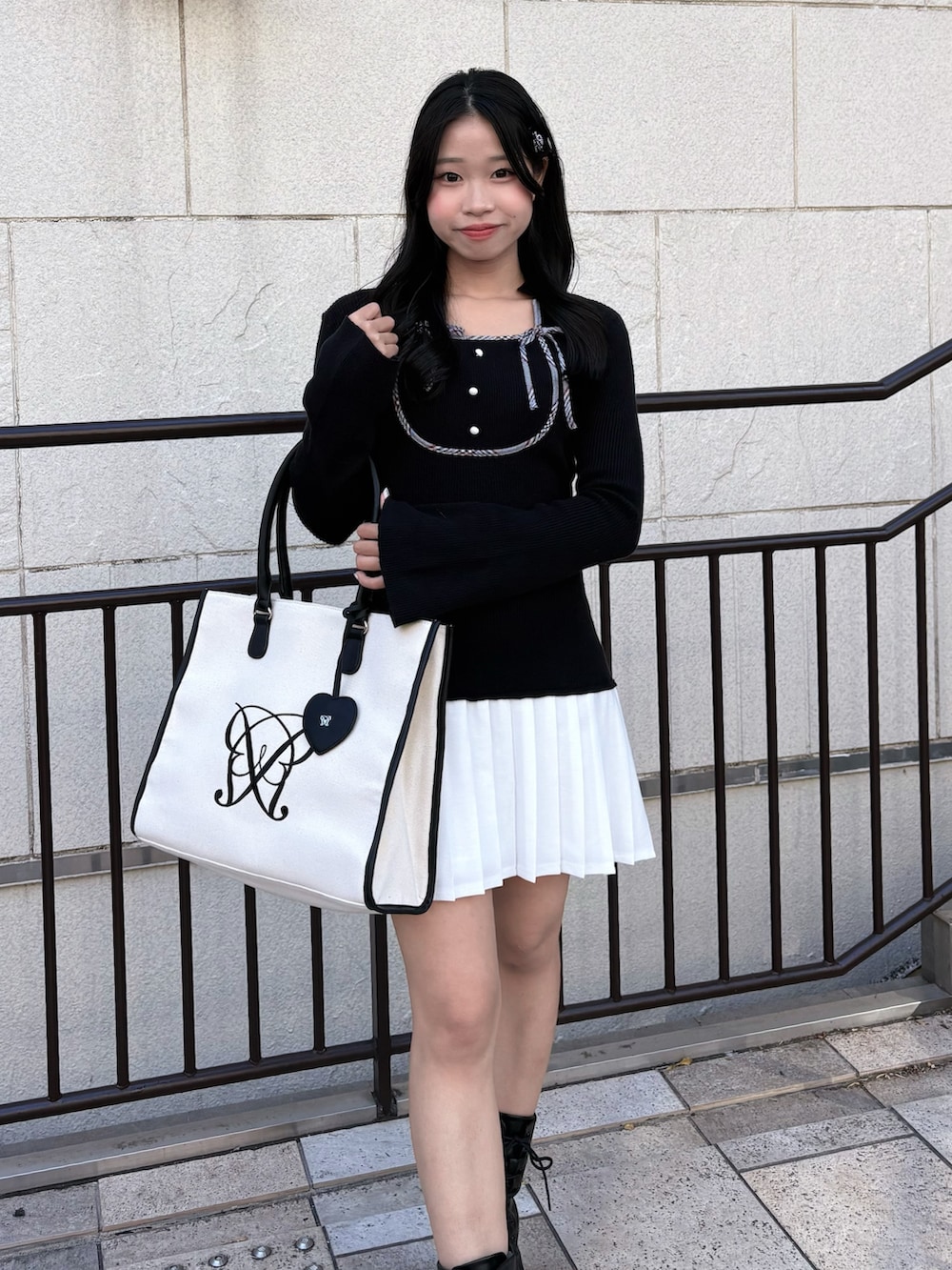 ブラック系のワンピース、ブラック系のブーツを着用したレディースの秋コーディネートの2枚目の写真