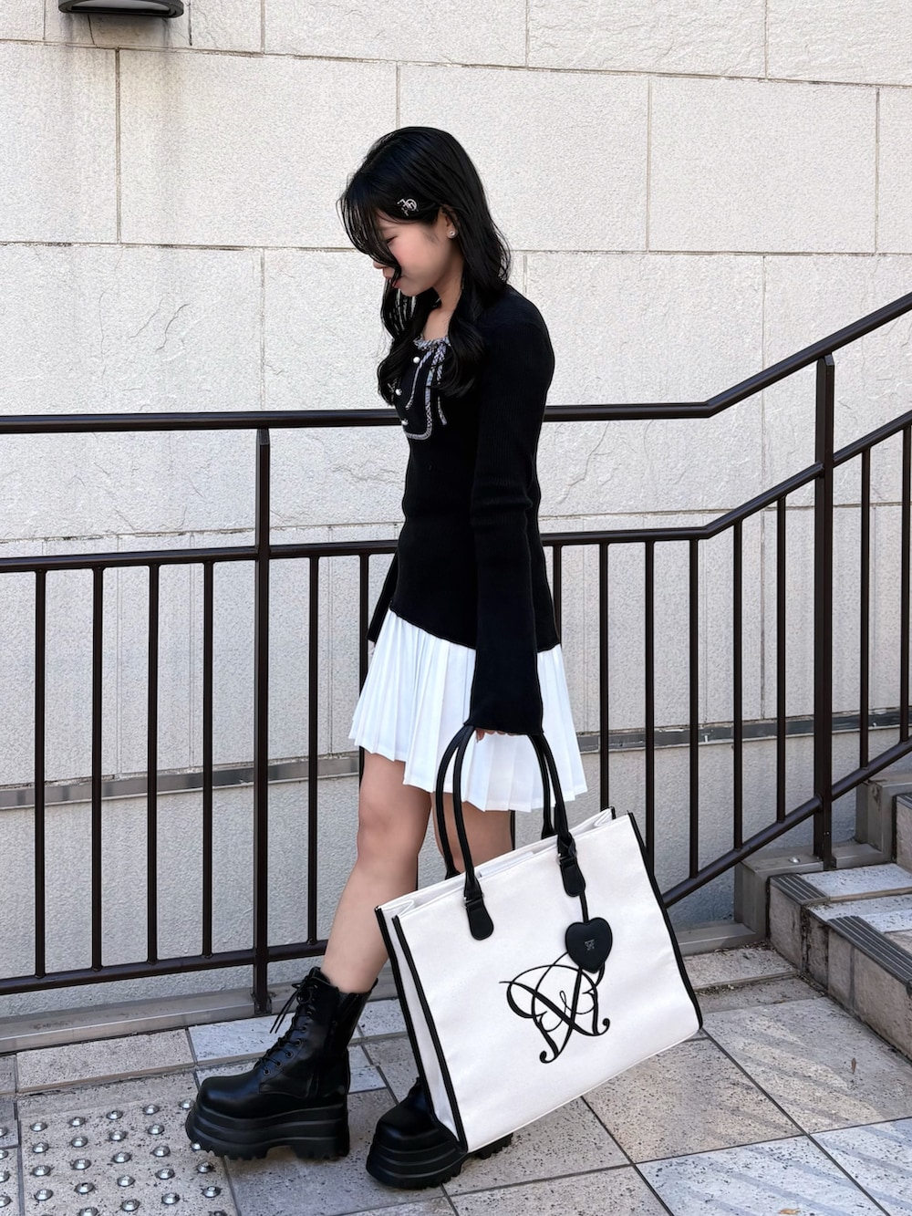 ブラック系のワンピース、ブラック系のブーツを着用したレディースの秋コーディネートの3枚目の写真