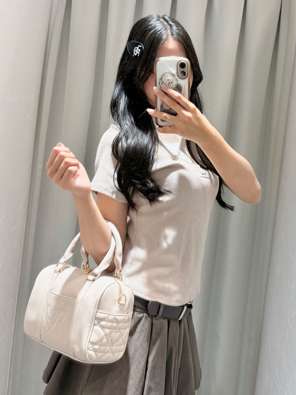 ベージュ系のTシャツ/カットソー、ブラウン系のスカート、ベージュ系のボストンバッグを着用したレディースの夏コーディネートの3枚目の写真