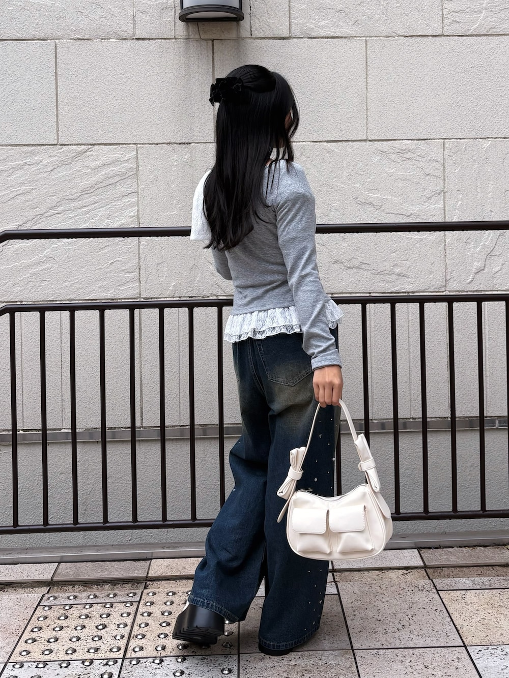 ブルー系のその他パンツ、グレー系のTシャツ/カットソー、ホワイト系のショルダーバッグを着用したレディースの冬コーディネートの3枚目の写真