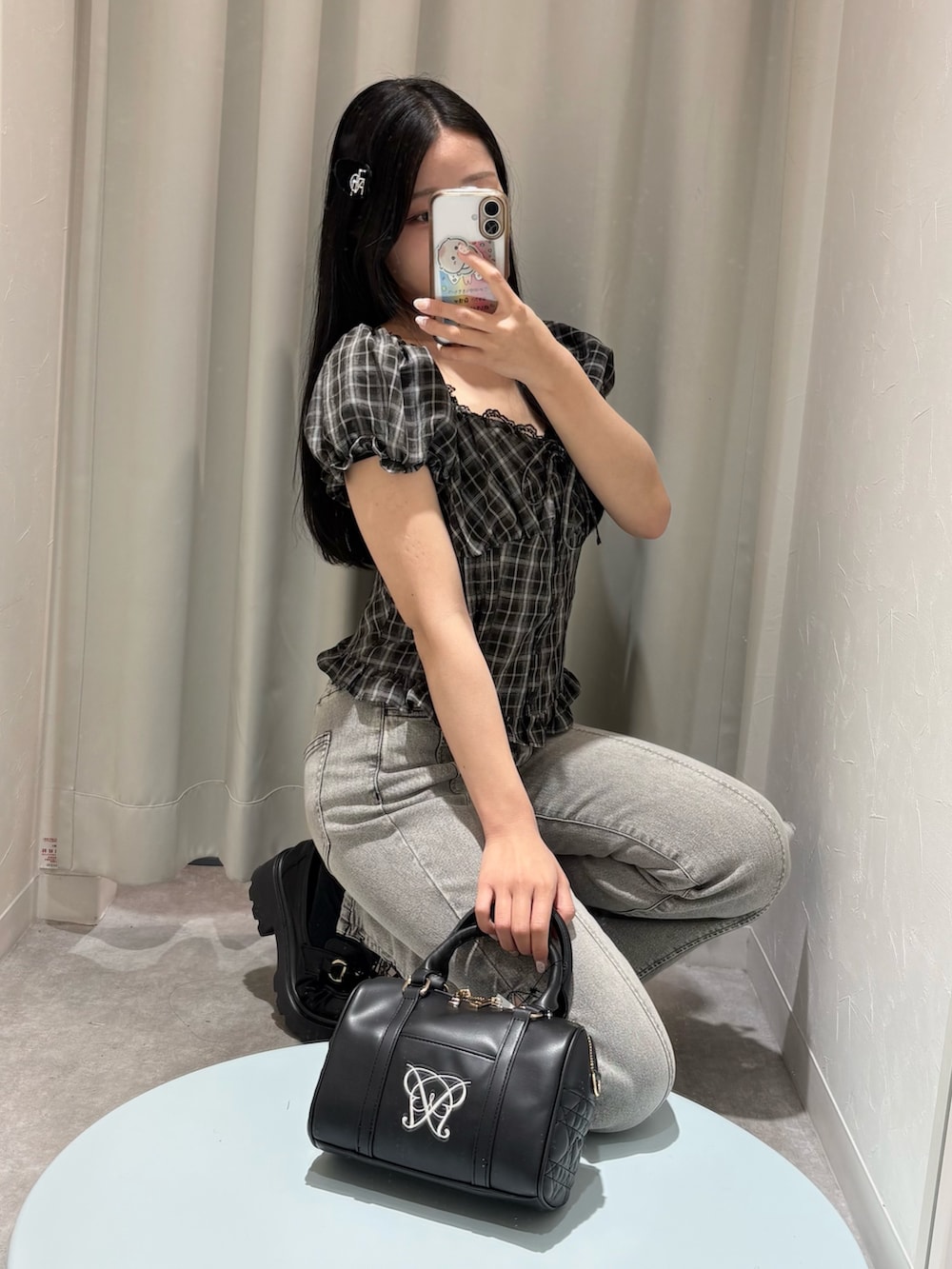 ブラック系のシャツ/ブラウス、グレー系のデニムパンツ、ブラック系のボストンバッグを着用したレディースの春コーディネートの3枚目の写真