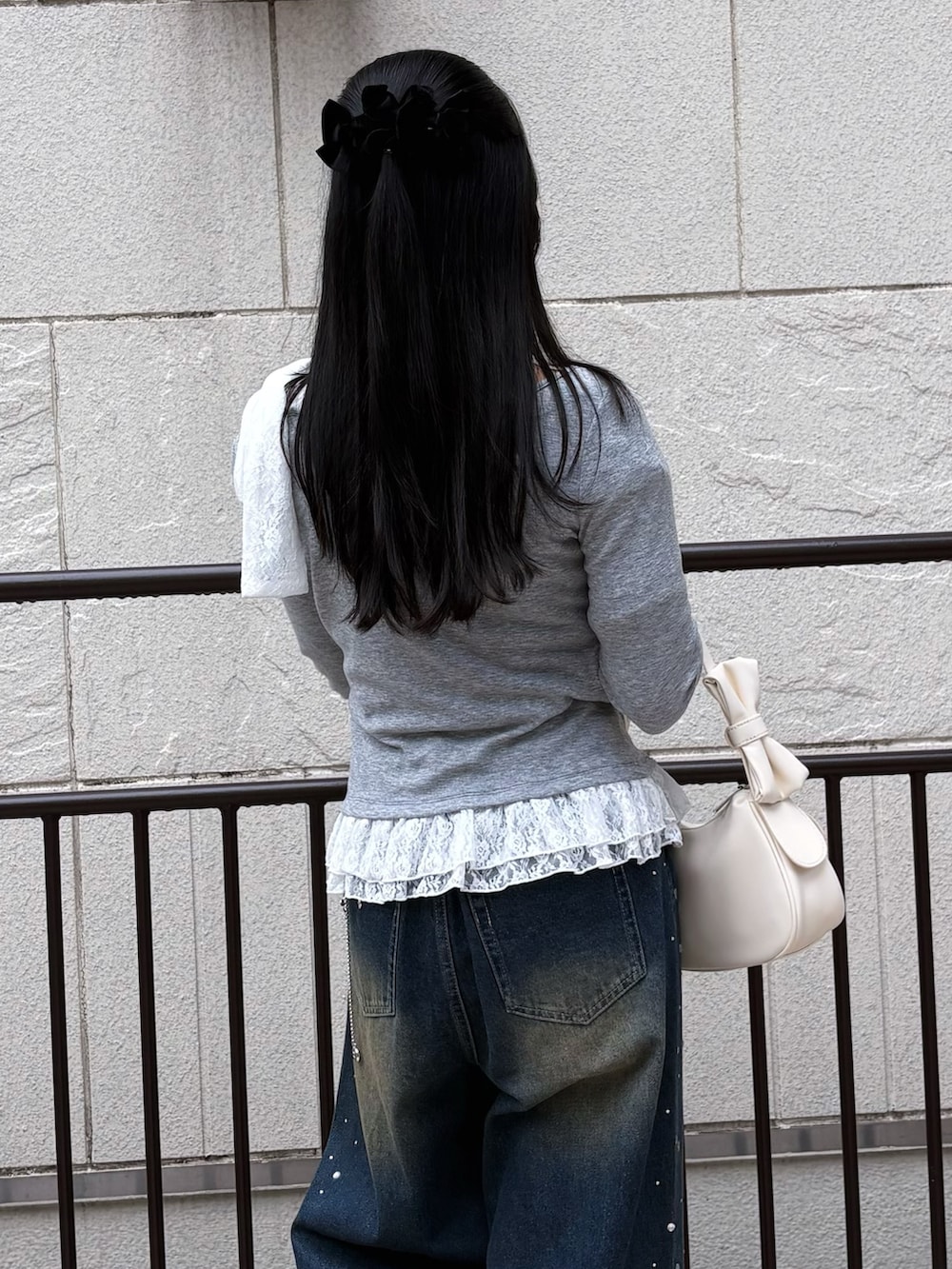 ブルー系のその他パンツ、グレー系のTシャツ/カットソー、ホワイト系のショルダーバッグを着用したレディースの冬コーディネートの5枚目の写真