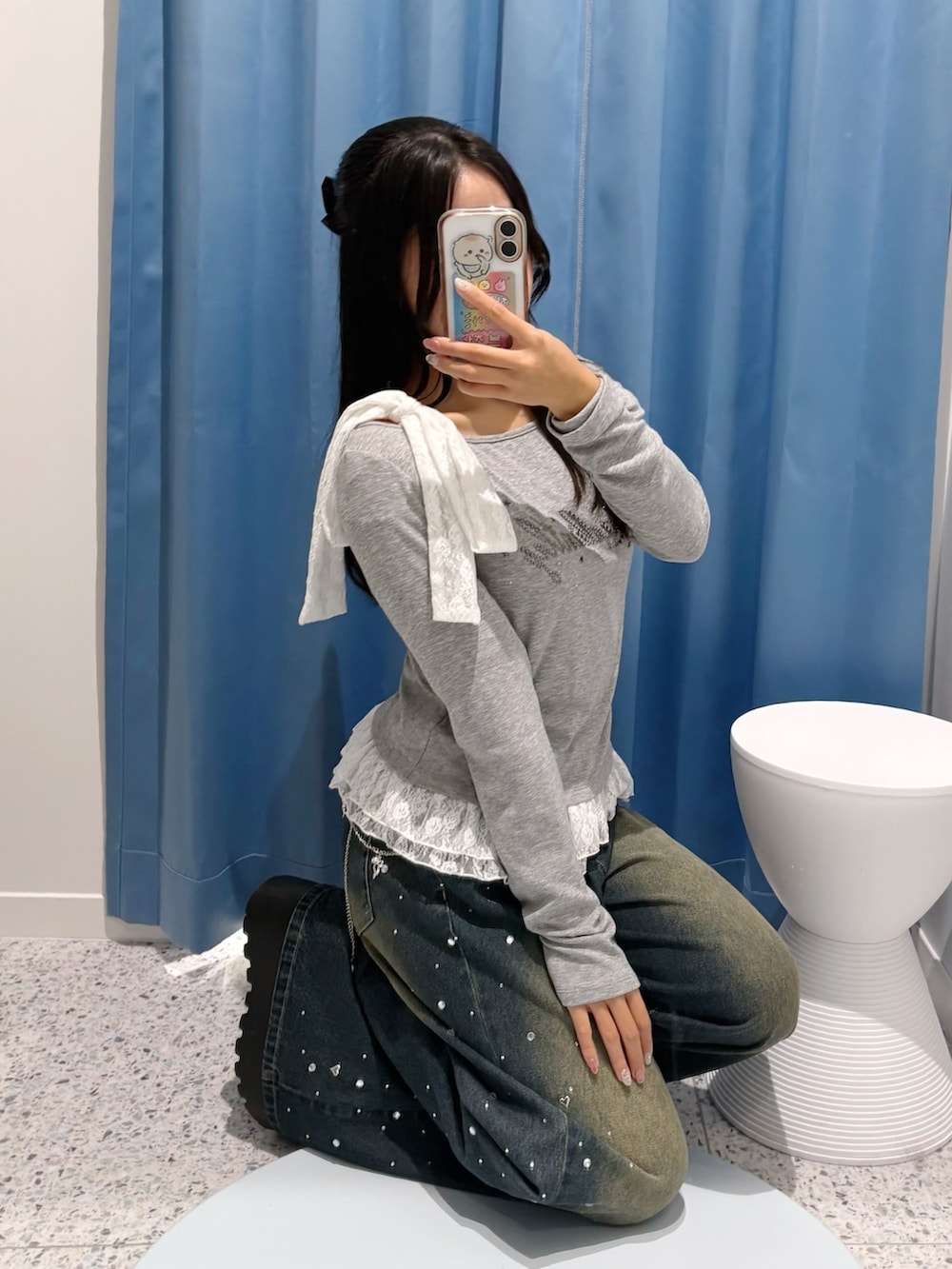 ブルー系のその他パンツ、グレー系のTシャツ/カットソー、ホワイト系のショルダーバッグを着用したレディースの冬コーディネートの6枚目の写真