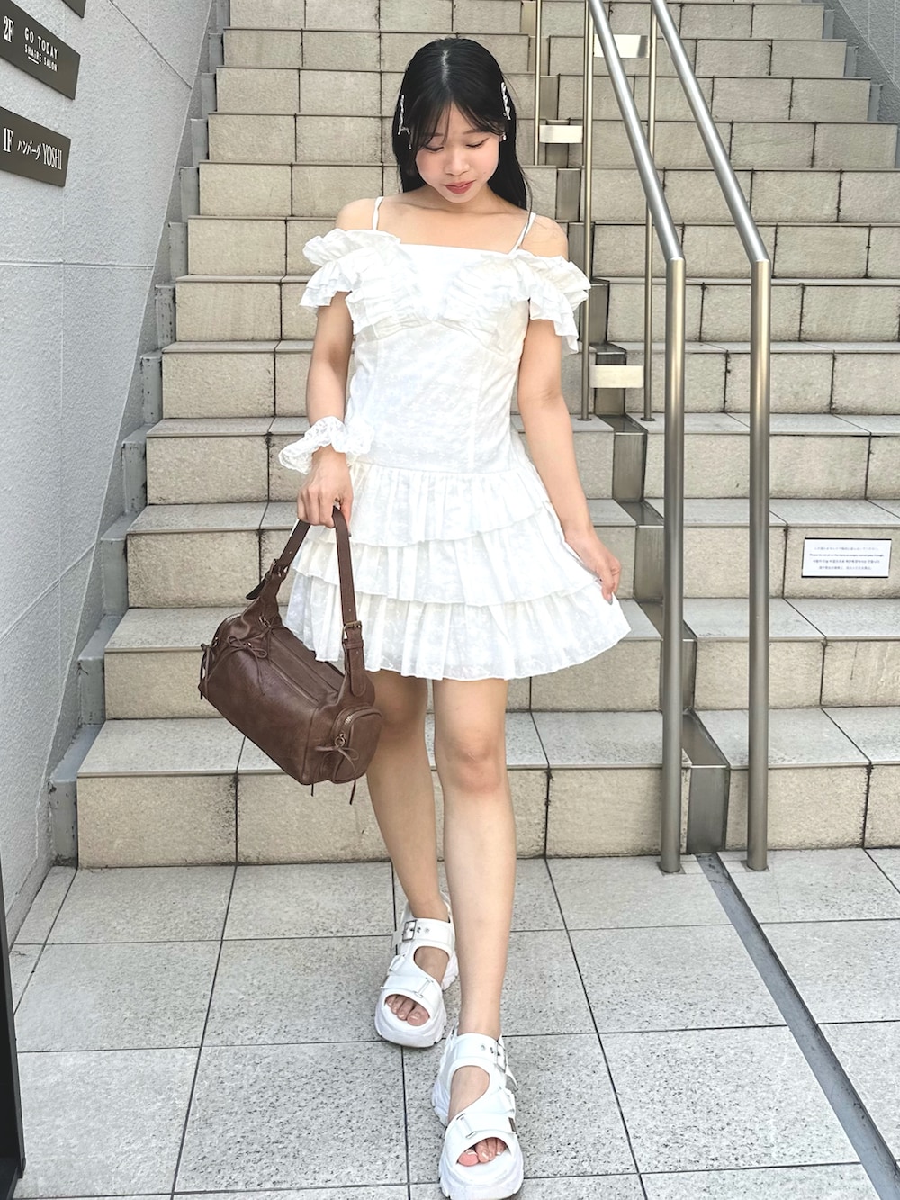 ホワイト系のワンピース、ホワイト系のサンダル、ブラウン系のショルダーバッグを着用したレディースの夏コーディネートの2枚目の写真