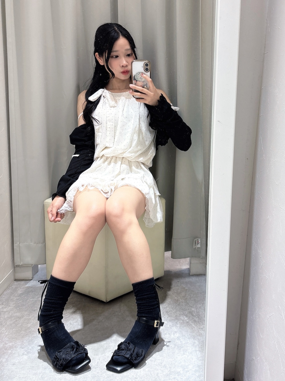 ホワイト系のワンピース、ブラック系のボストンバッグ、ブラック系のサンダルを着用したレディースの夏コーディネートの2枚目の写真