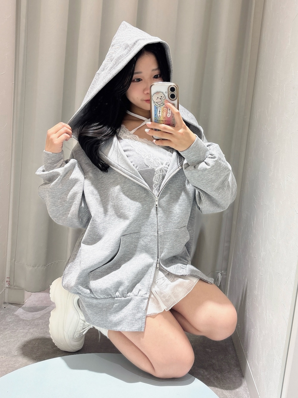 グレー系のパーカー、ホワイト系のスカート、グレー系のTシャツ/カットソーを着用したレディースの春コーディネートの3枚目の写真