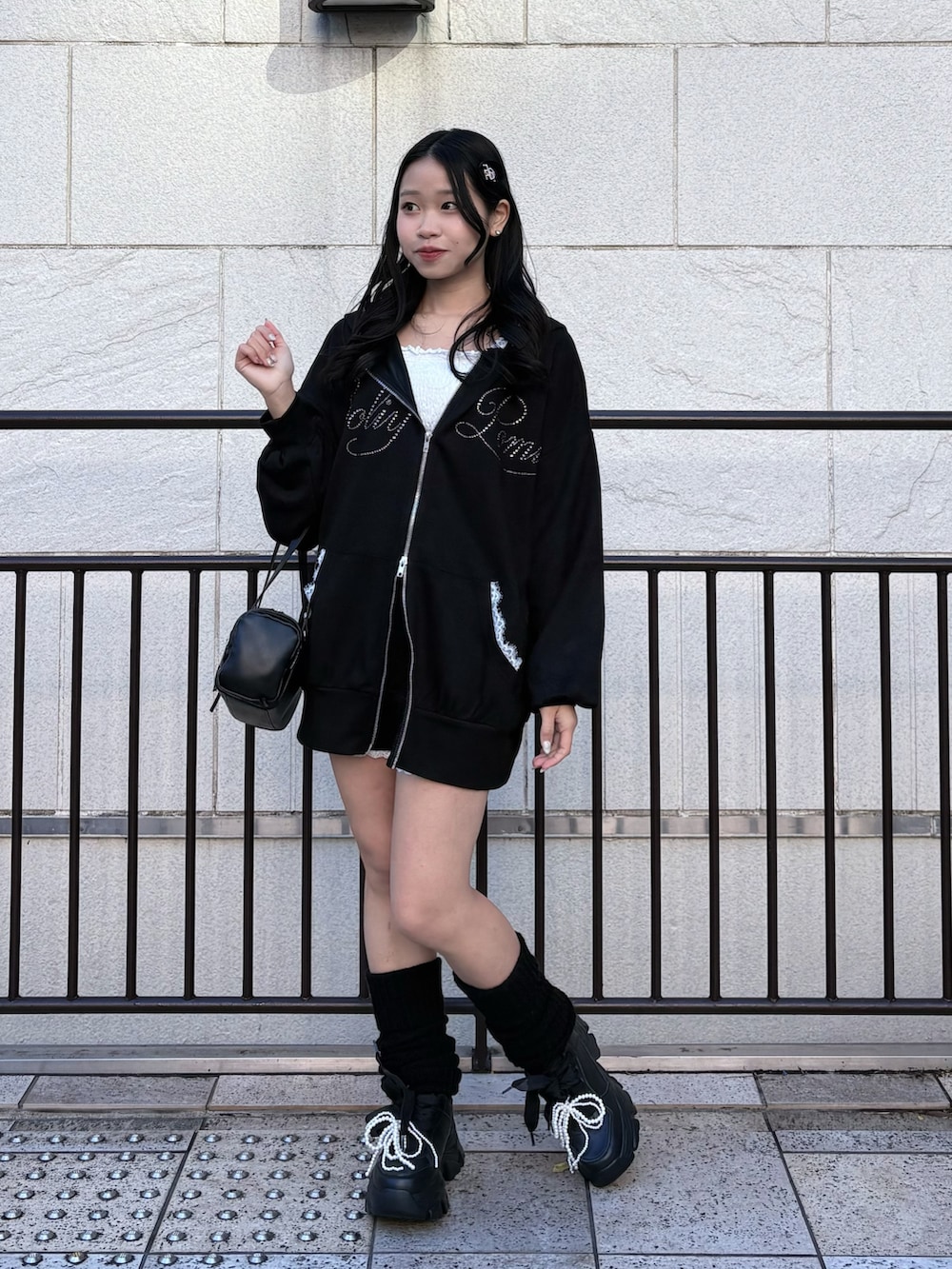 ブラック系のパーカー、ブラック系のその他パンツ、ブラック系のスニーカーを着用したレディースの冬コーディネートの3枚目の写真