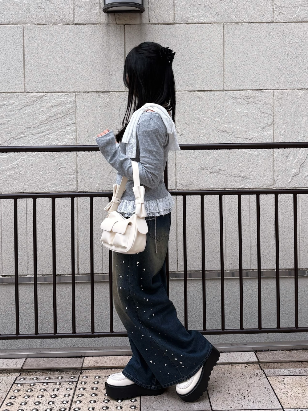 ブルー系のその他パンツ、グレー系のTシャツ/カットソー、ホワイト系のショルダーバッグを着用したレディースの冬コーディネートの4枚目の写真