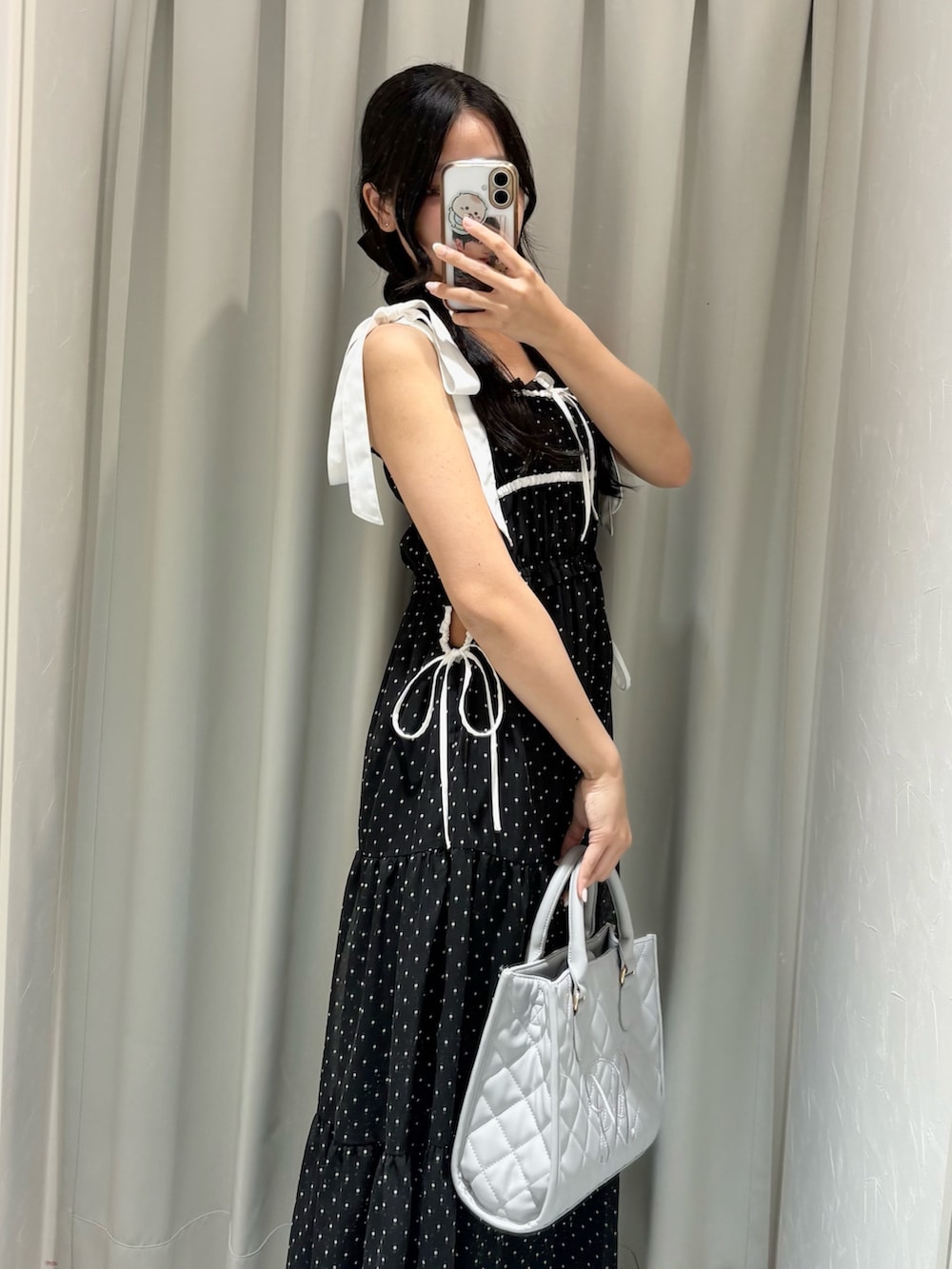 ブラック系のワンピース、グレー系のショルダーバッグ、ブラック系のサンダルを着用したレディースの春コーディネートの3枚目の写真