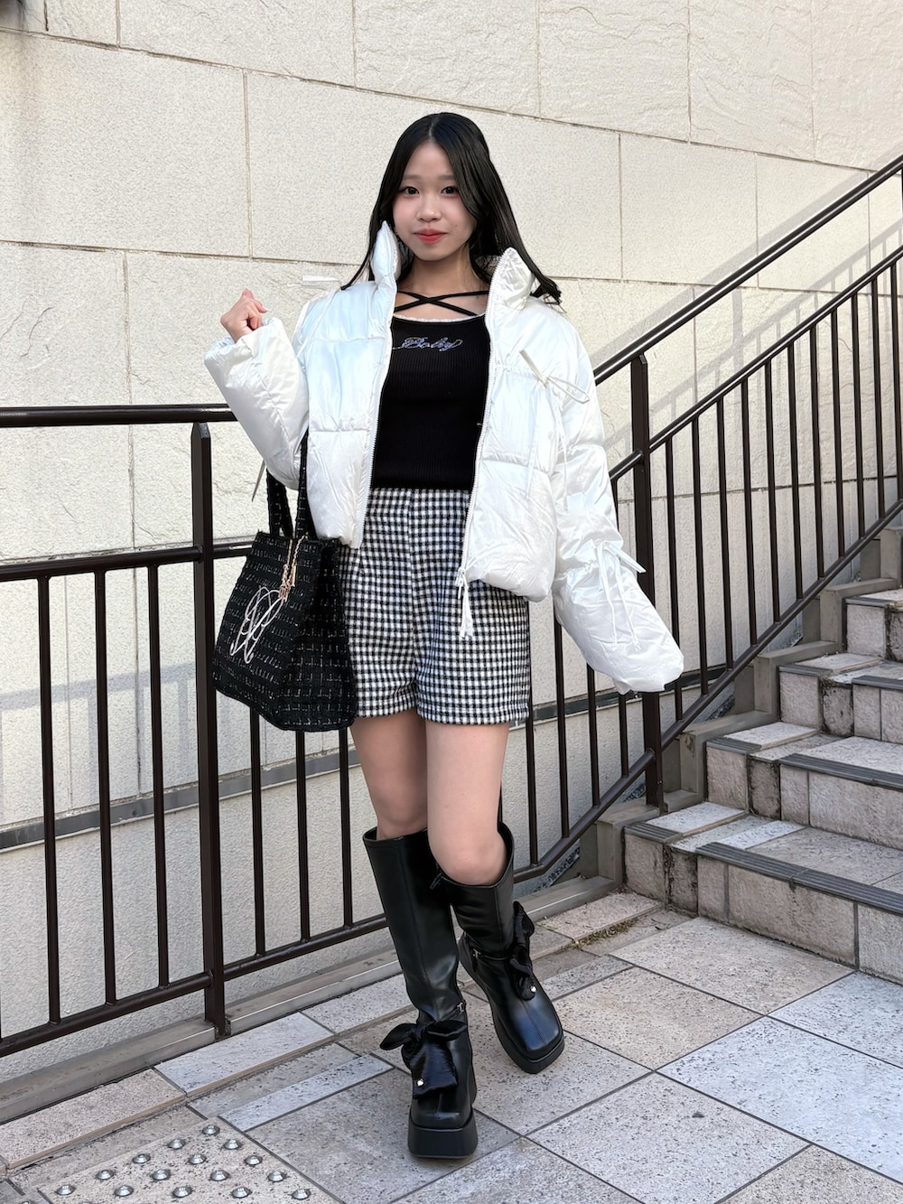 ブラック系のニット/セーター、ホワイト系のダウンジャケット/コート、その他のその他パンツを着用したレディースの冬コーディネートの2枚目の写真