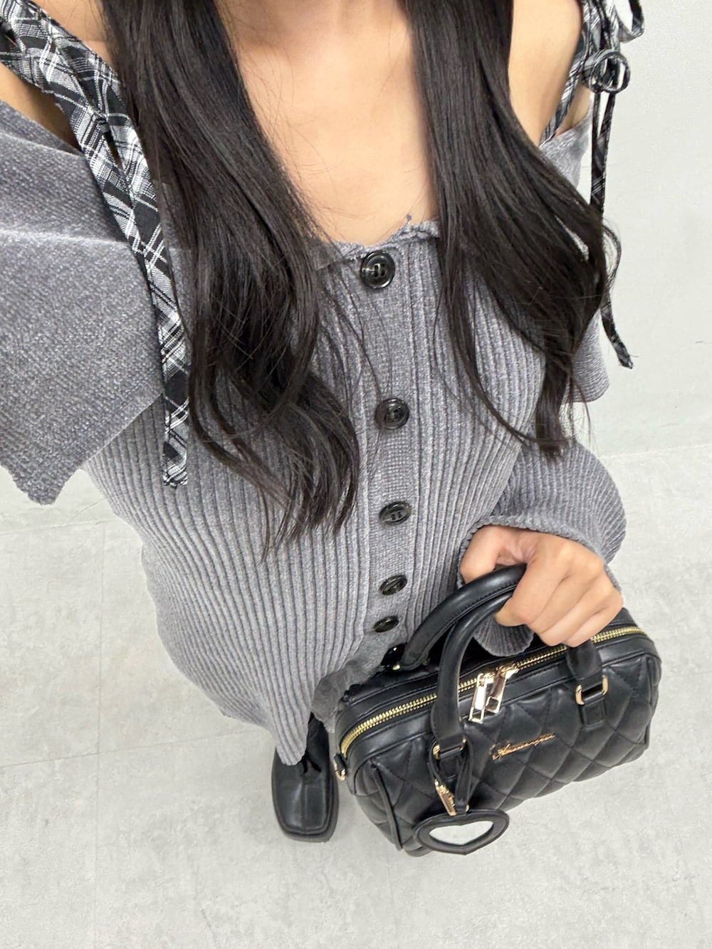 グレー系のワンピース、ブラック系のボストンバッグ、ブラック系のブーツを着用したレディースの夏コーディネートの4枚目の写真