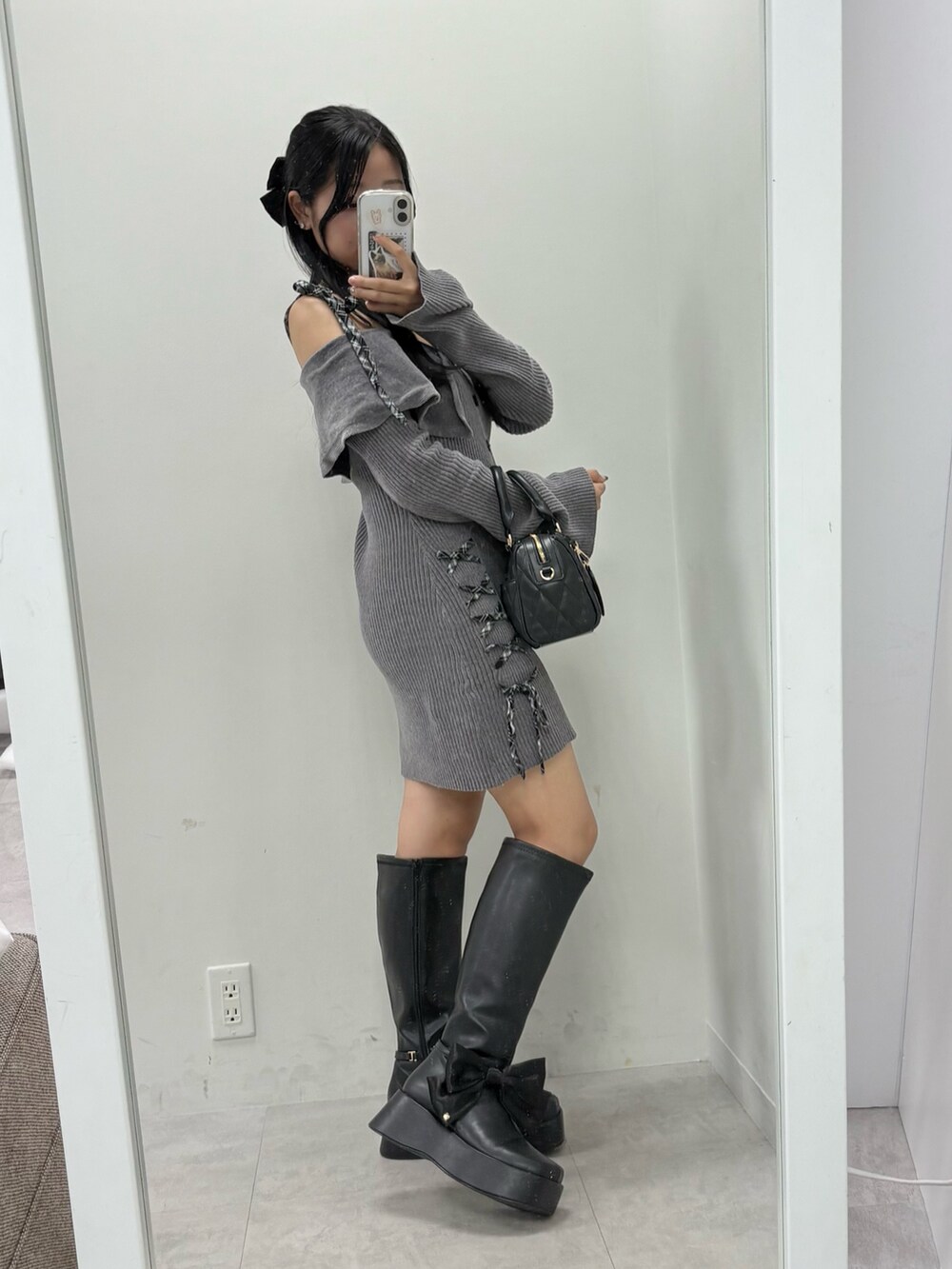 グレー系のワンピース、ブラック系のボストンバッグ、ブラック系のブーツを着用したレディースの夏コーディネートの3枚目の写真