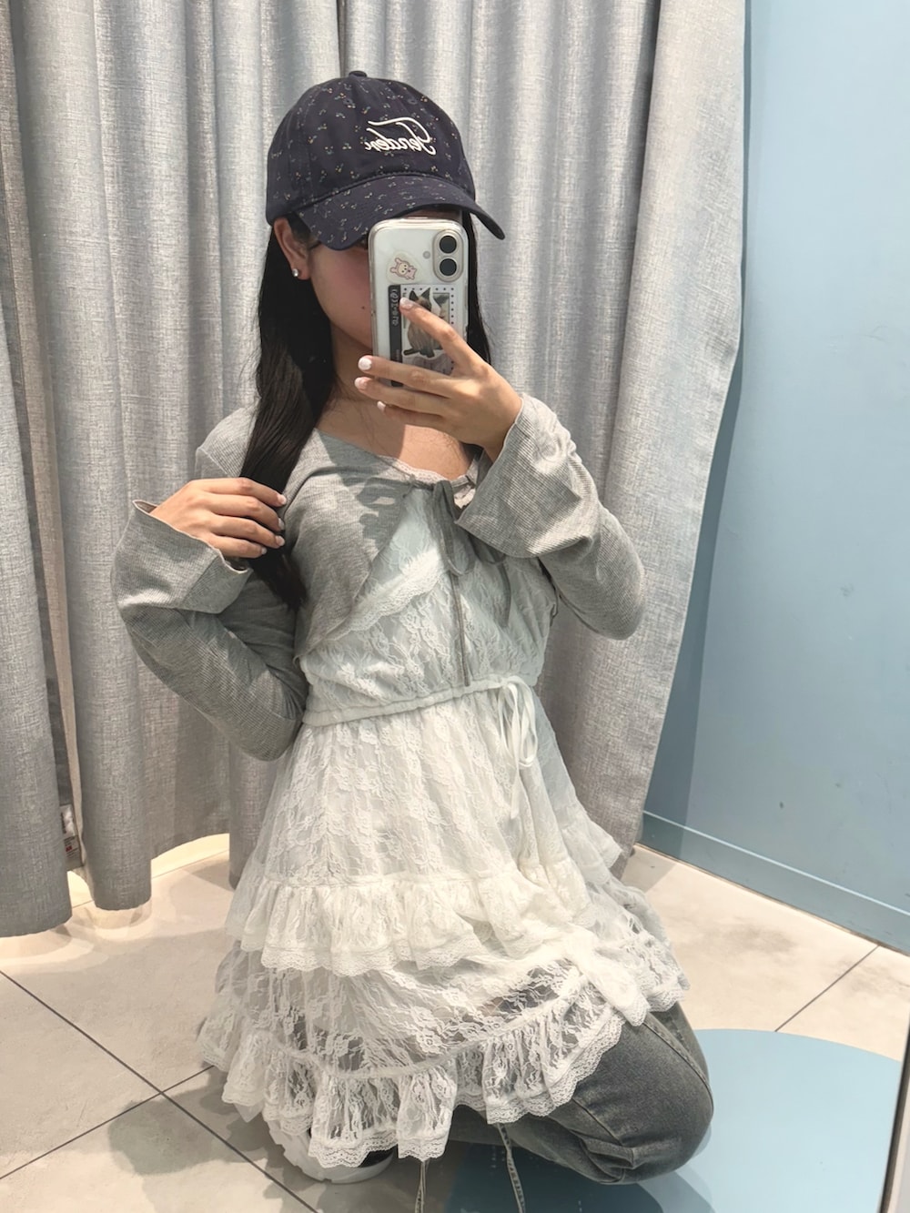 ホワイト系のワンピース、ブルー系のデニムパンツ、ブラック系のサンダルを着用したレディースの夏コーディネートの2枚目の写真