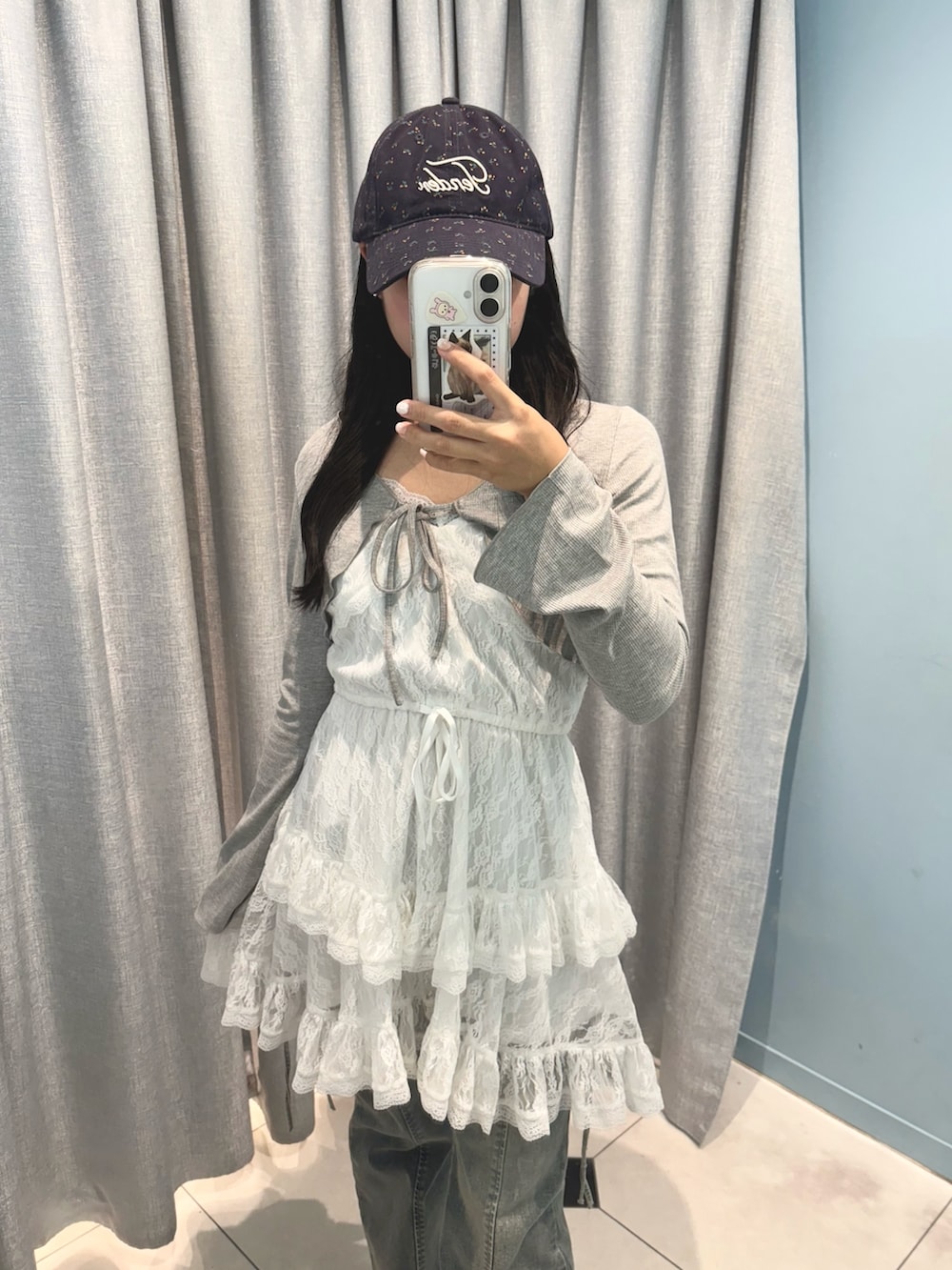 ホワイト系のワンピース、ブルー系のデニムパンツ、ブラック系のサンダルを着用したレディースの夏コーディネートの3枚目の写真