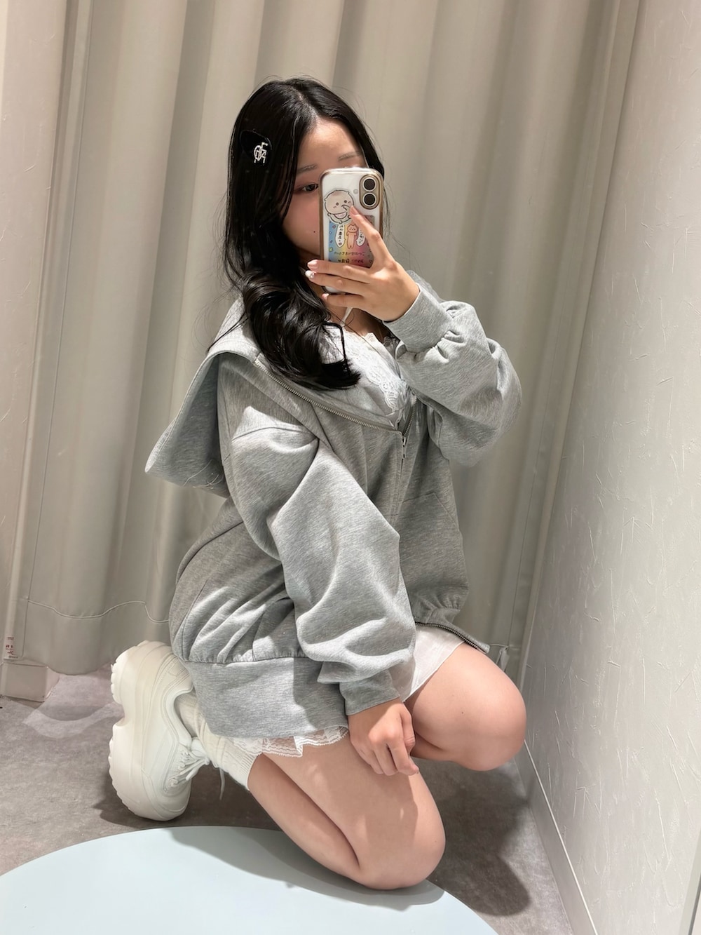 グレー系のパーカー、ホワイト系のスカート、グレー系のTシャツ/カットソーを着用したレディースの春コーディネートの2枚目の写真