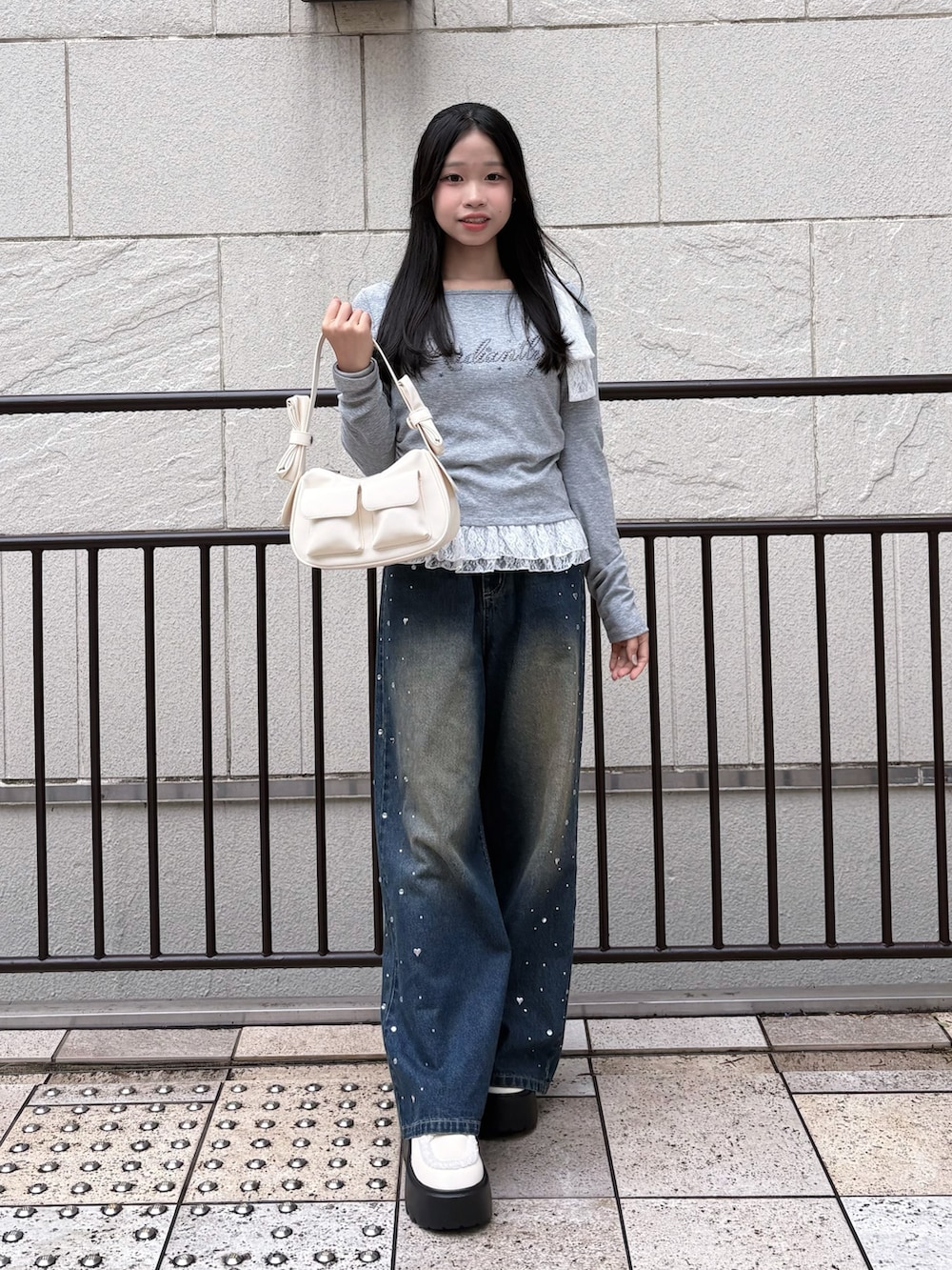 ブルー系のその他パンツ、グレー系のTシャツ/カットソー、ホワイト系のショルダーバッグを着用したレディースの冬コーディネートの2枚目の写真