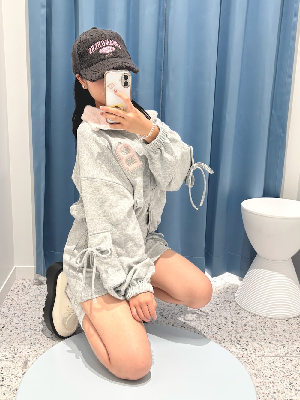 グレー系のTシャツ/カットソー、グレー系のスカート、ホワイト系のその他シューズを着用したレディースの秋コーディネートの3枚目の写真