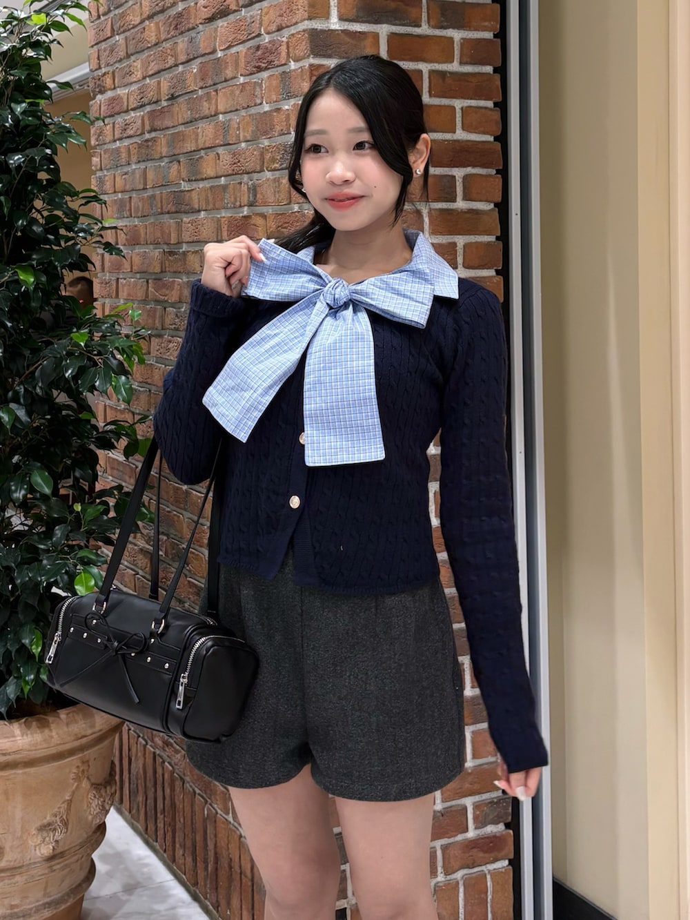 ブルー系のニット/セーター、グレー系のその他パンツ、ブラック系のトートバッグを着用したレディースの冬コーディネートの2枚目の写真