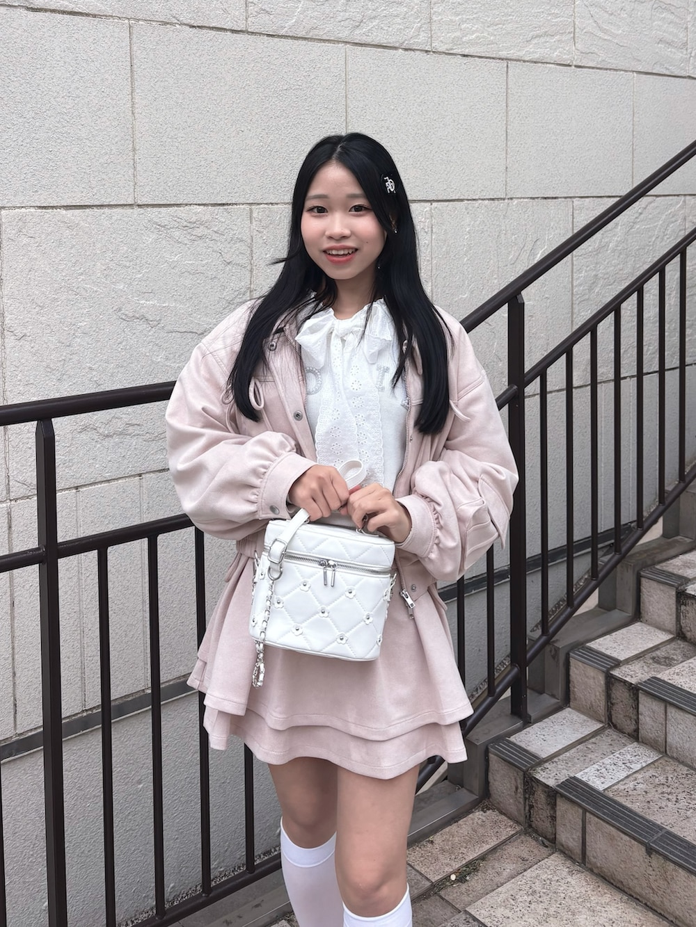 ピンク系のブルゾン、ピンク系のスカート、ホワイト系のニット/セーターを着用したレディースの冬コーディネートの3枚目の写真