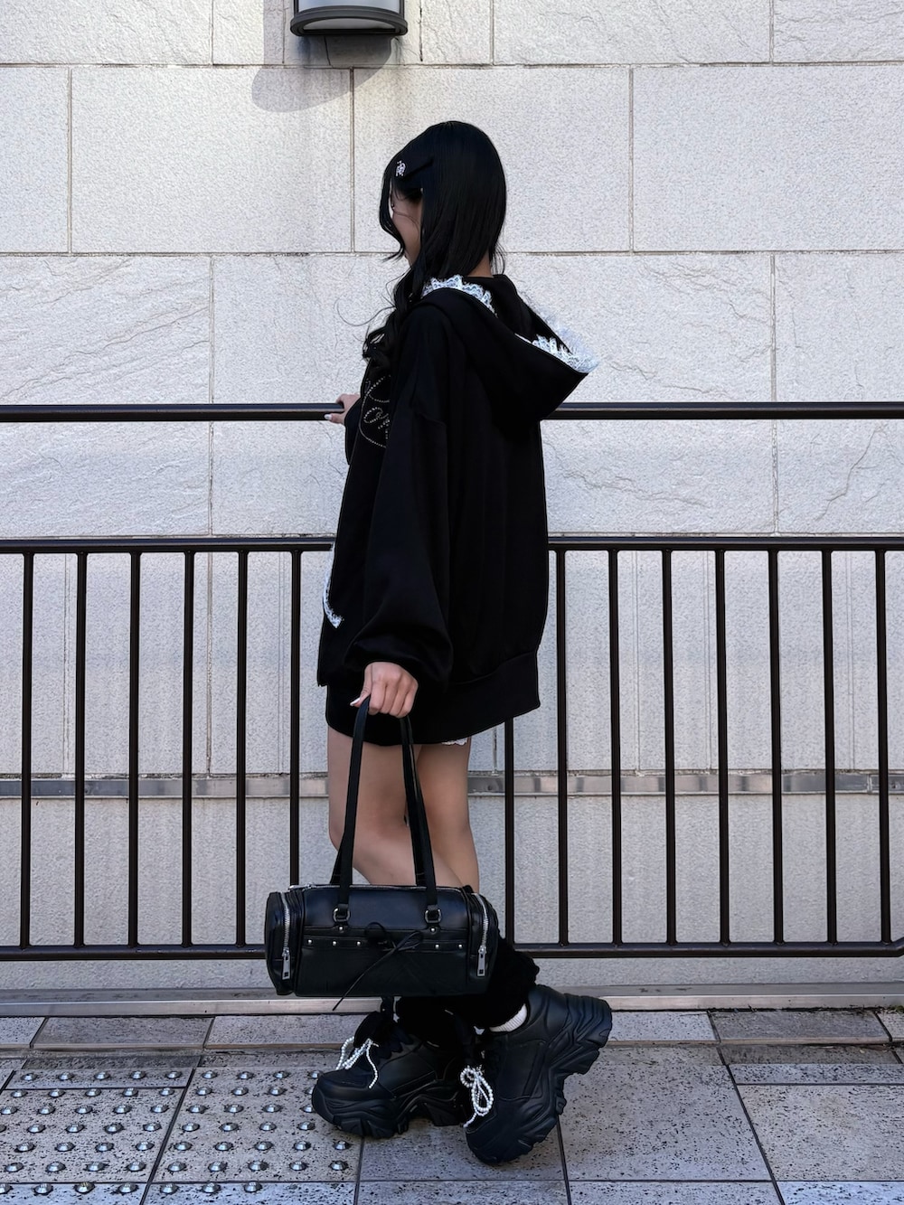 ブラック系のパーカー、ブラック系のその他パンツ、ブラック系のスニーカーを着用したレディースの冬コーディネートの5枚目の写真