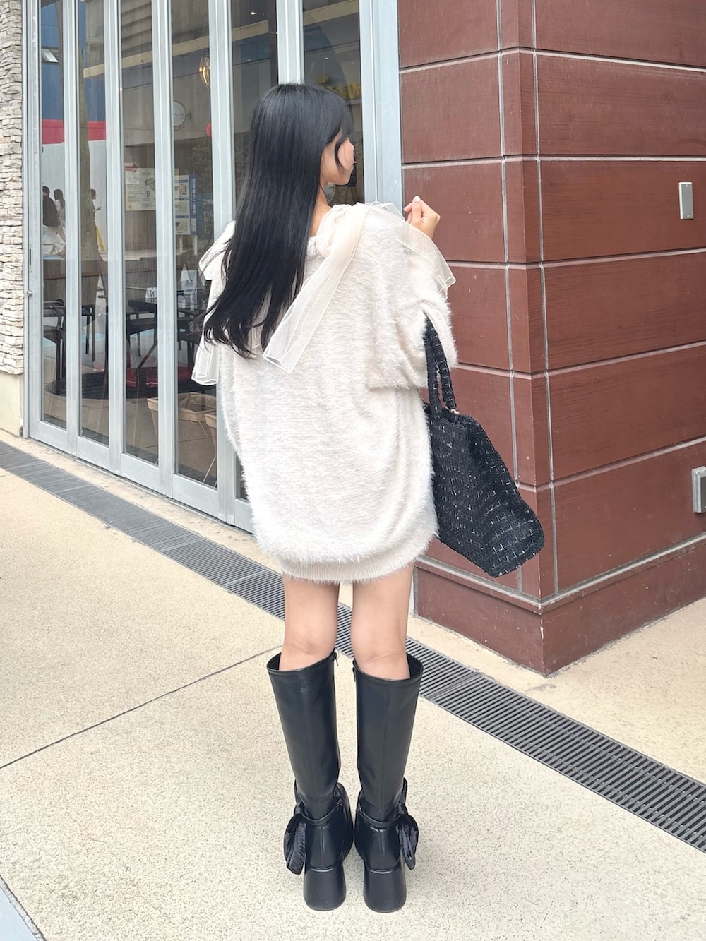 ピンク系のカーディガン/ボレロ、ピンク系のキャミソール、ブラック系のトートバッグを着用したレディースの秋コーディネートの3枚目の写真