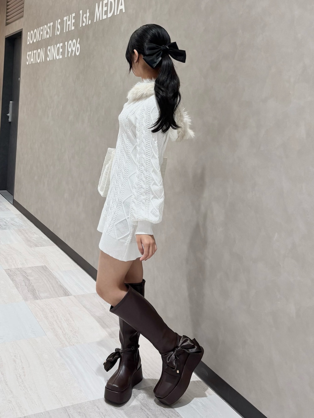 ブラウン系のブーツ、ホワイト系のトートバッグ、ホワイト系のワンピースを着用したレディースの秋コーディネートの3枚目の写真